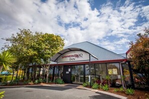 Springwood Inn on modernisti suunniteltu majatalo, jossa on katettu sisäänkäynti ja kauniisti hoidettu puutarha.