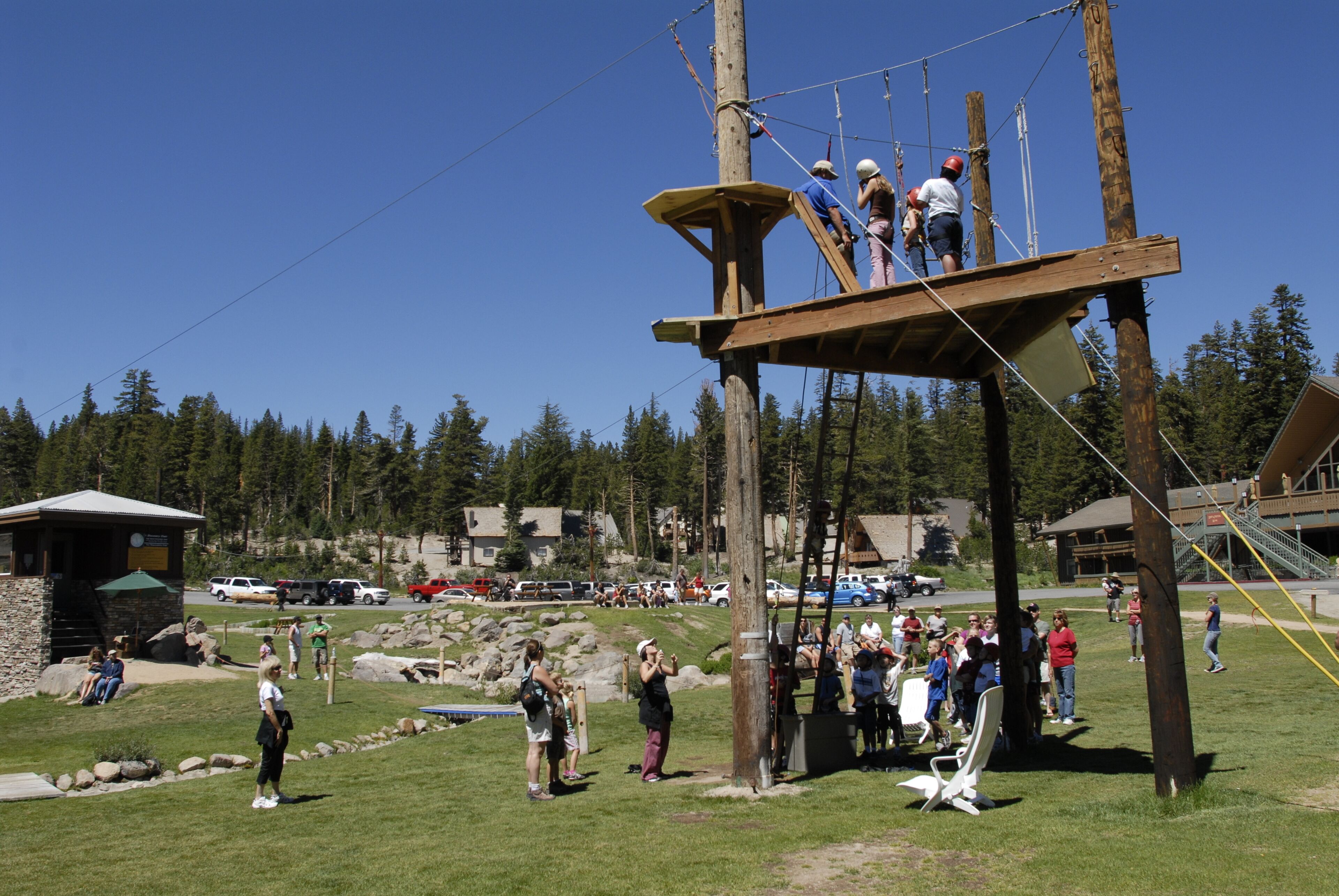 A wooden platform with ropes and a group of people standing on it.