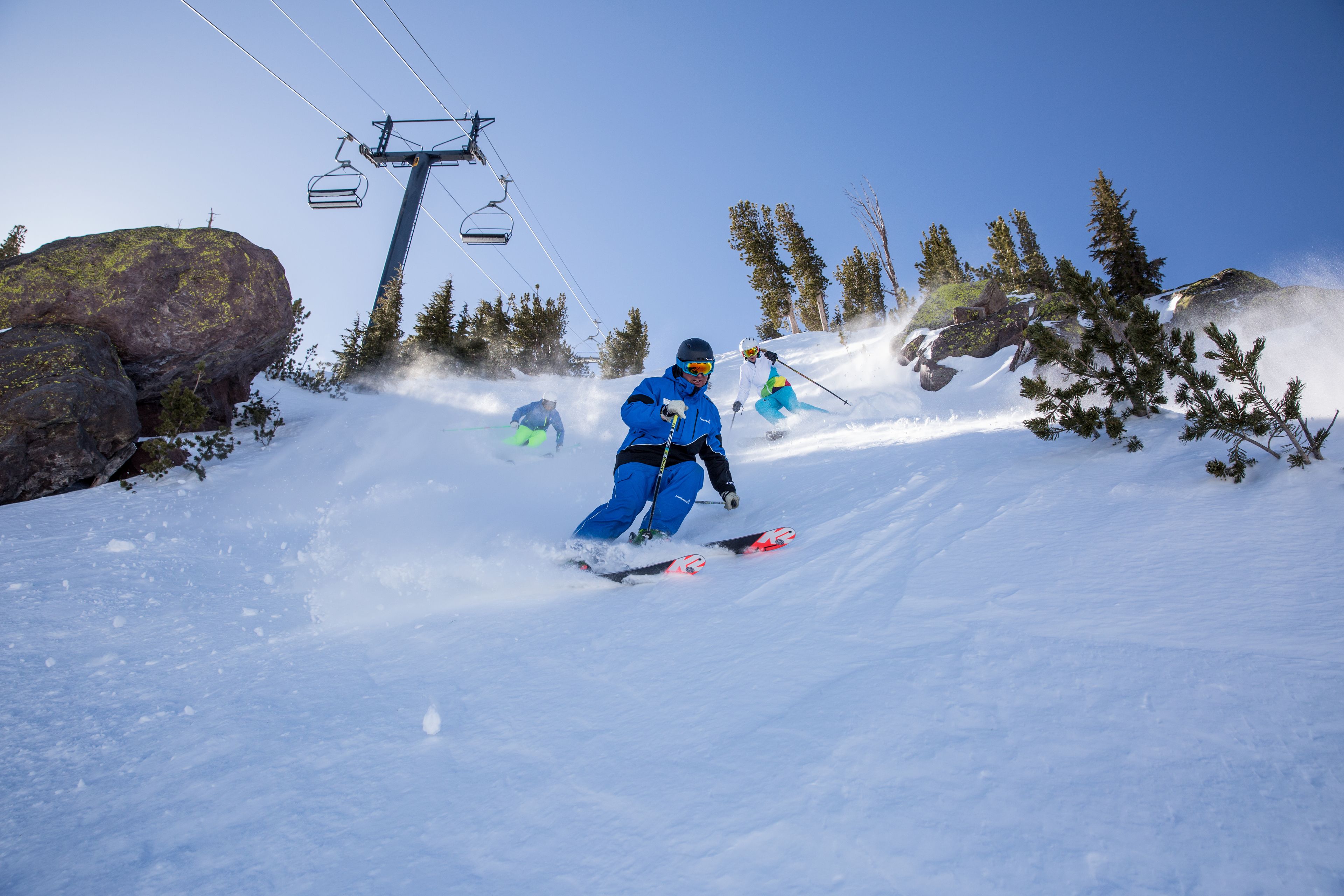 Una persona scia sulle piste innevate, con una seggiovia sullo sfondo.