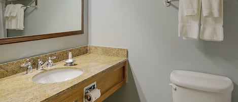 A bathroom with a sink, mirror, towel rack, and toilet.