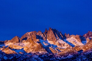 A mountain range with snow-covered peaks and a clear sky.