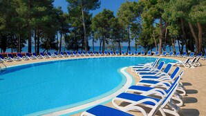 A pool area with blue lounge chairs and a clear sky. - Hotel Aurora Plava Laguna (Umag)