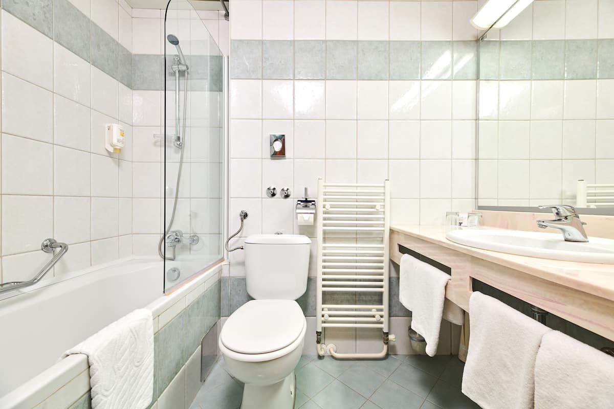 A modern bathroom with a bathtub, toilet, and a shower area.