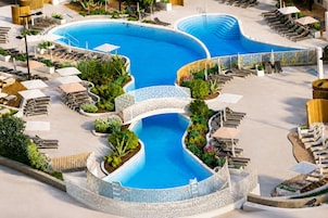 Una piscina techada, una piscina al aire libre de temporada, sombrillas