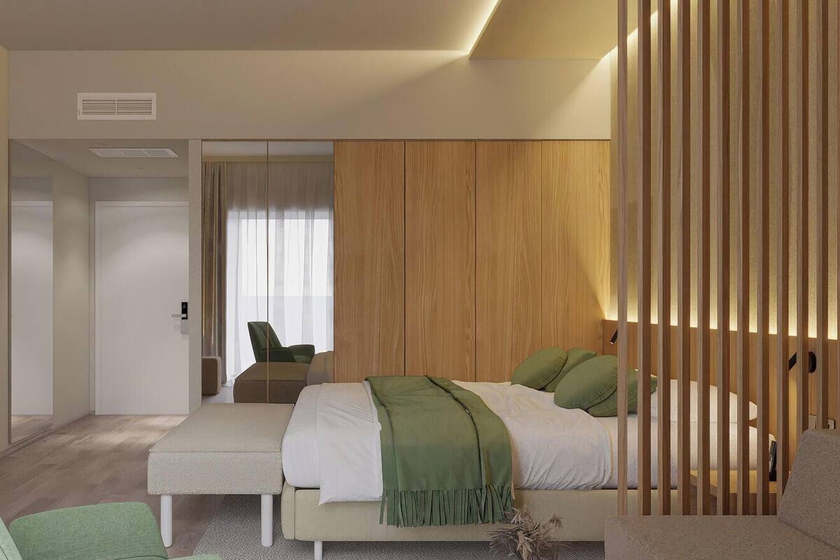Een moderne slaapkamer met een bed, een zithoek en een houten scheidingswand.