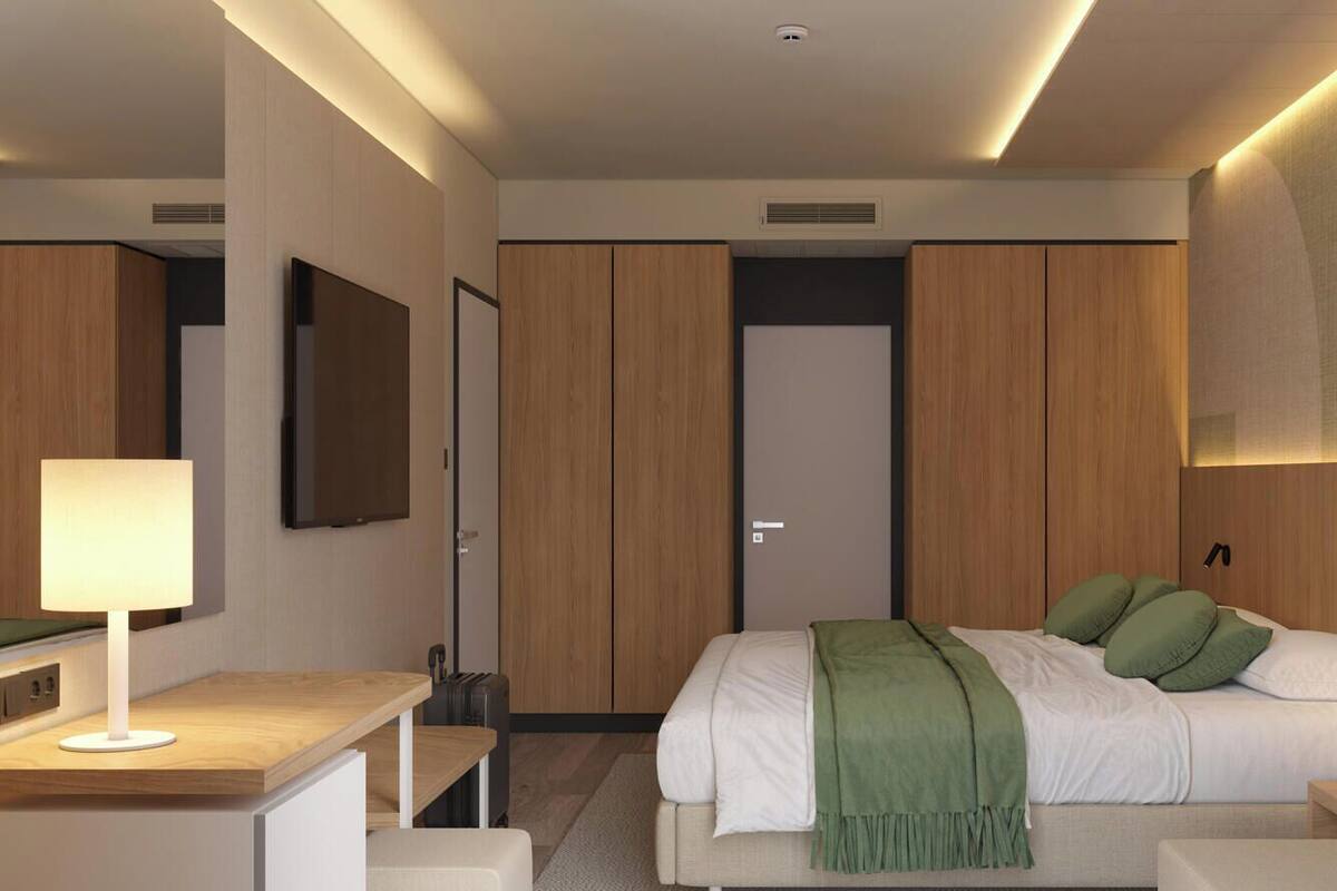Een moderne hotelkamer met een groot bed, nachtkastjes, een bureau en een kledingkast.