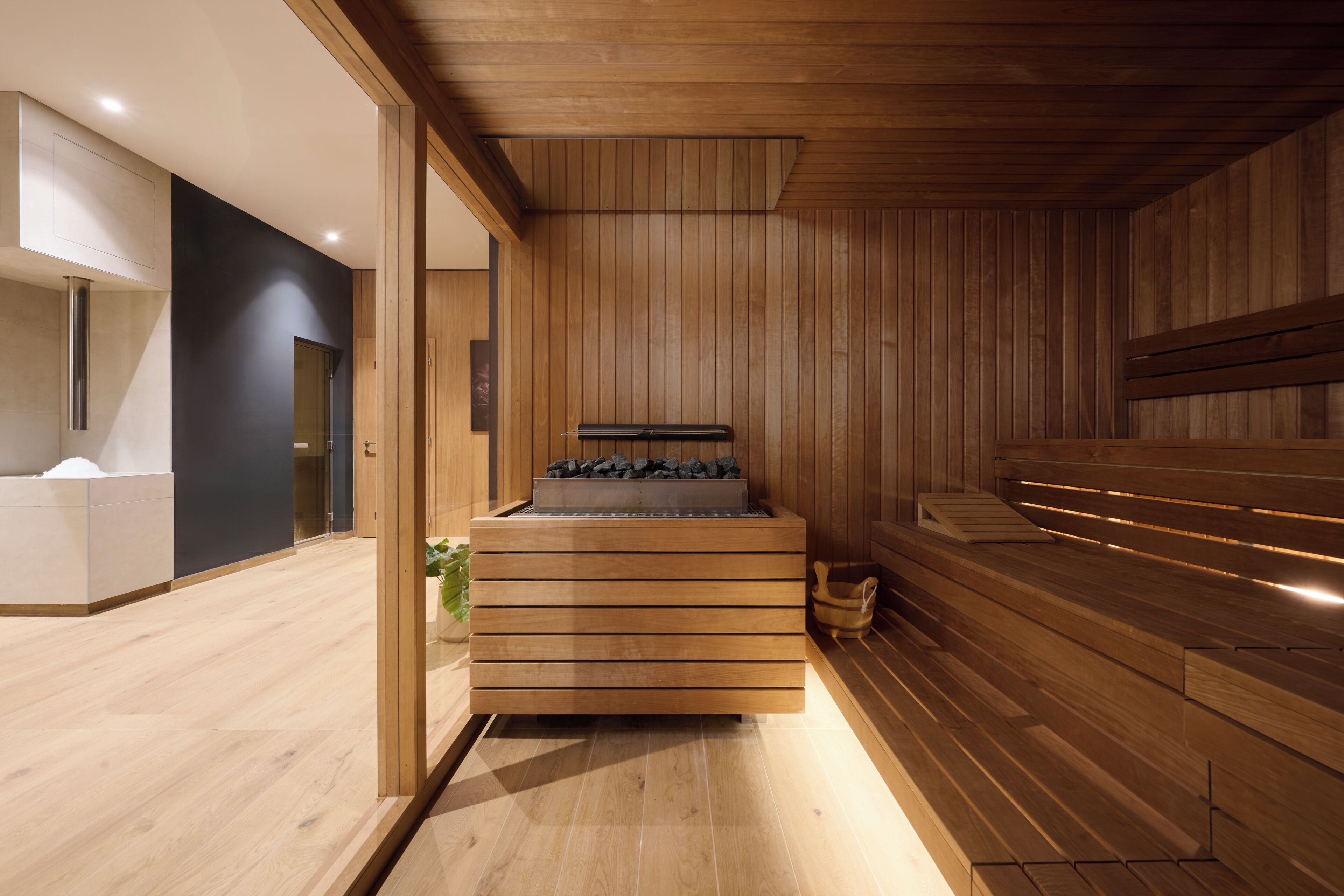 A modern sauna room with wooden walls and a bench.