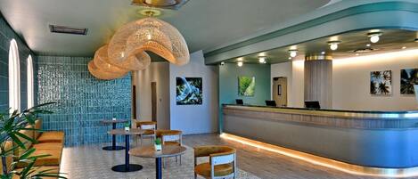 A modern reception area with a curved counter, seating arrangements, and artwork on the walls.