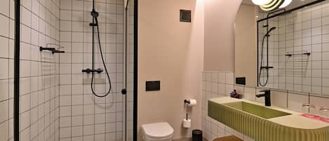 Un baño moderno con ducha, inodoro y lavabo.