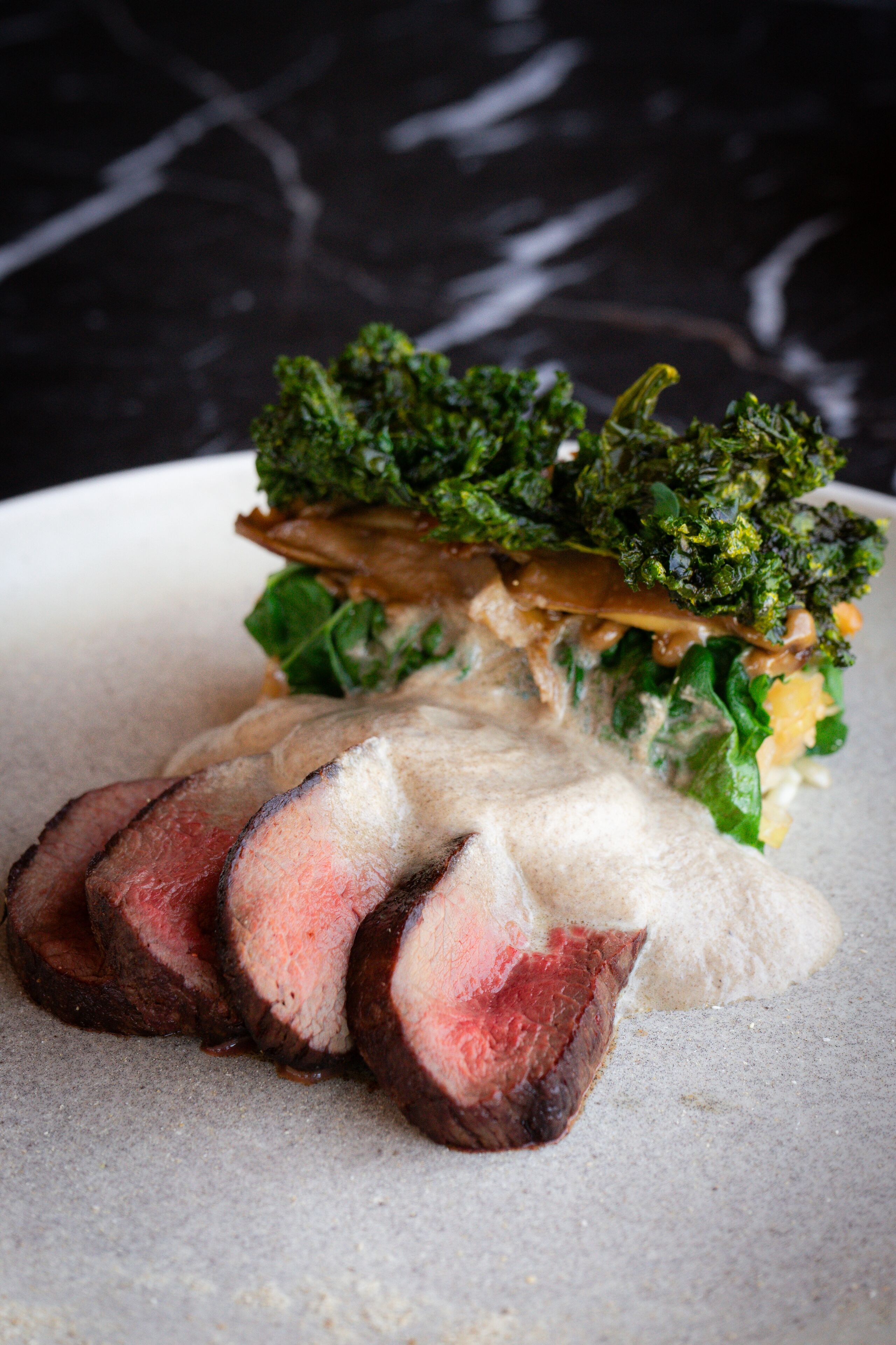 A plate with sliced meat and greens.