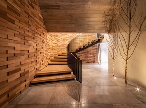 A modern interior with a wooden wall and a spiral staircase.