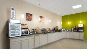 Una barra de desayuno equipada con refrigerador, microondas, tostadora y cafetera.