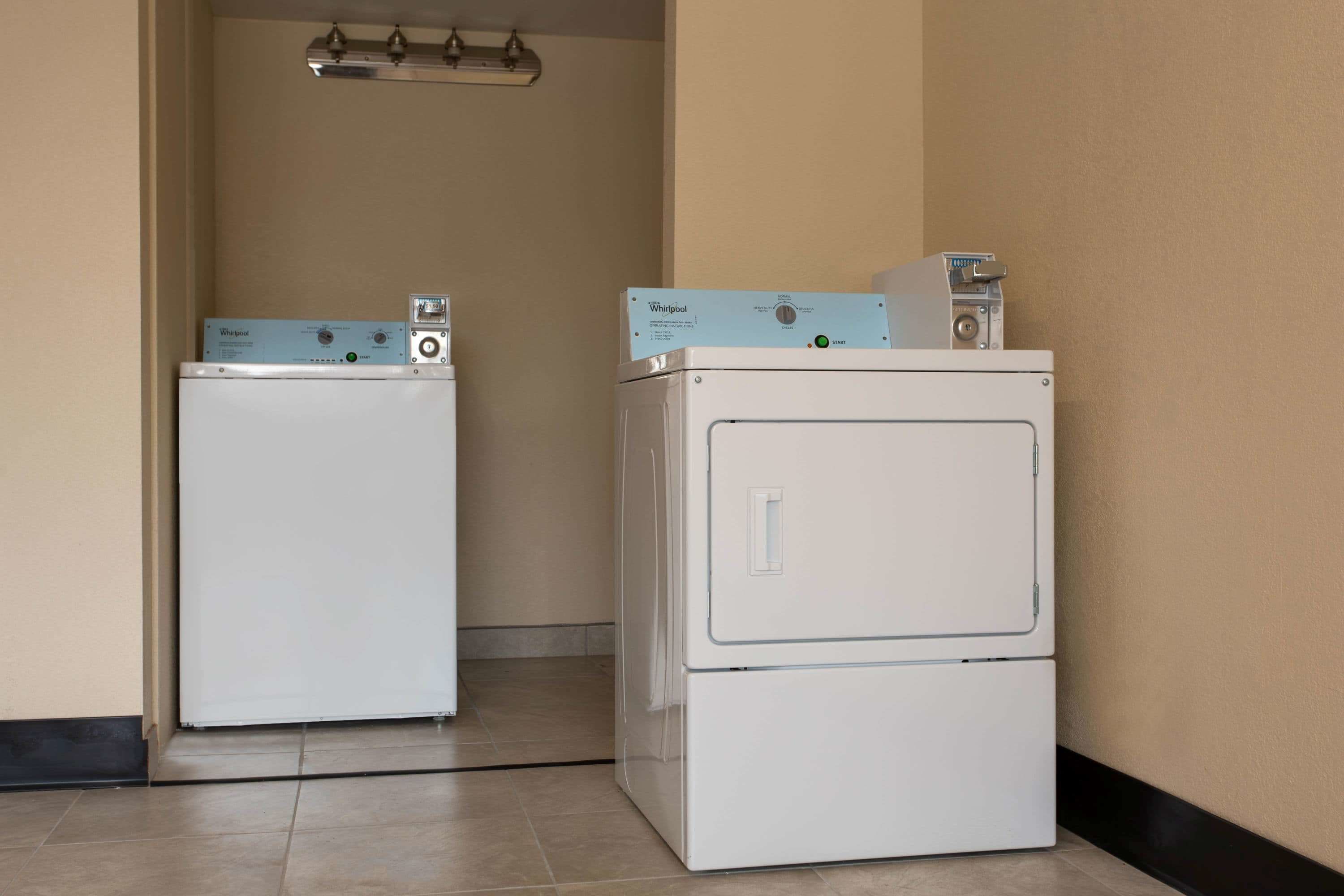 A laundry room with two stacked Whirlpool washers and dryers.
