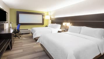 Habitación de hotel con dos camas, un escritorio, una silla, un televisor y un ventanal grande.