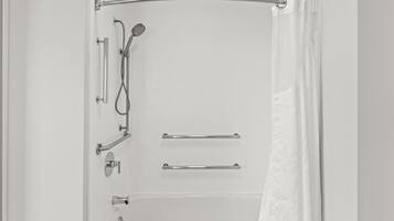 A modern bathroom with a walk-in shower, grab bars, and a towel rack.