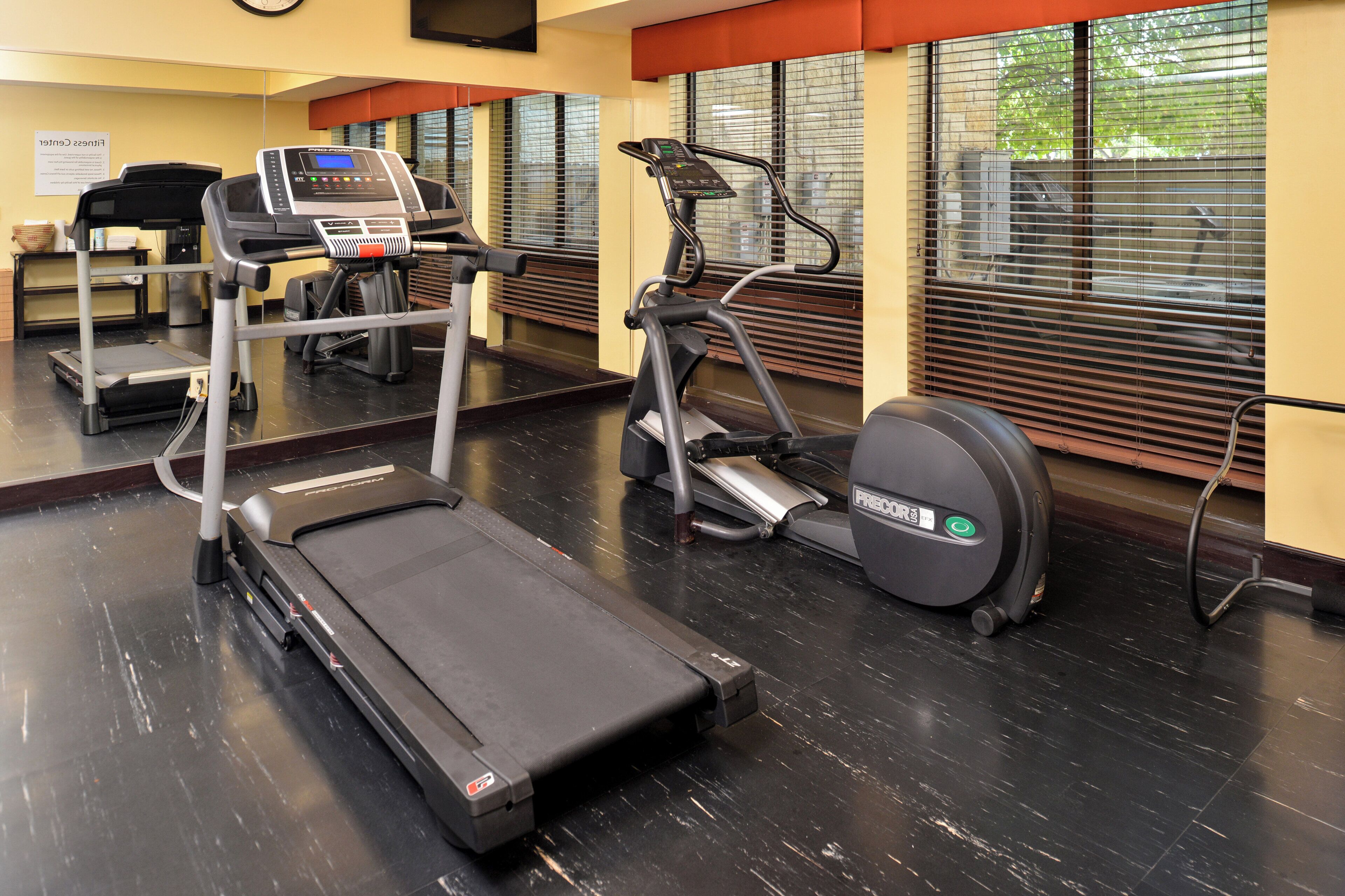 A gym with treadmills, a stationary bike, and a rowing machine.