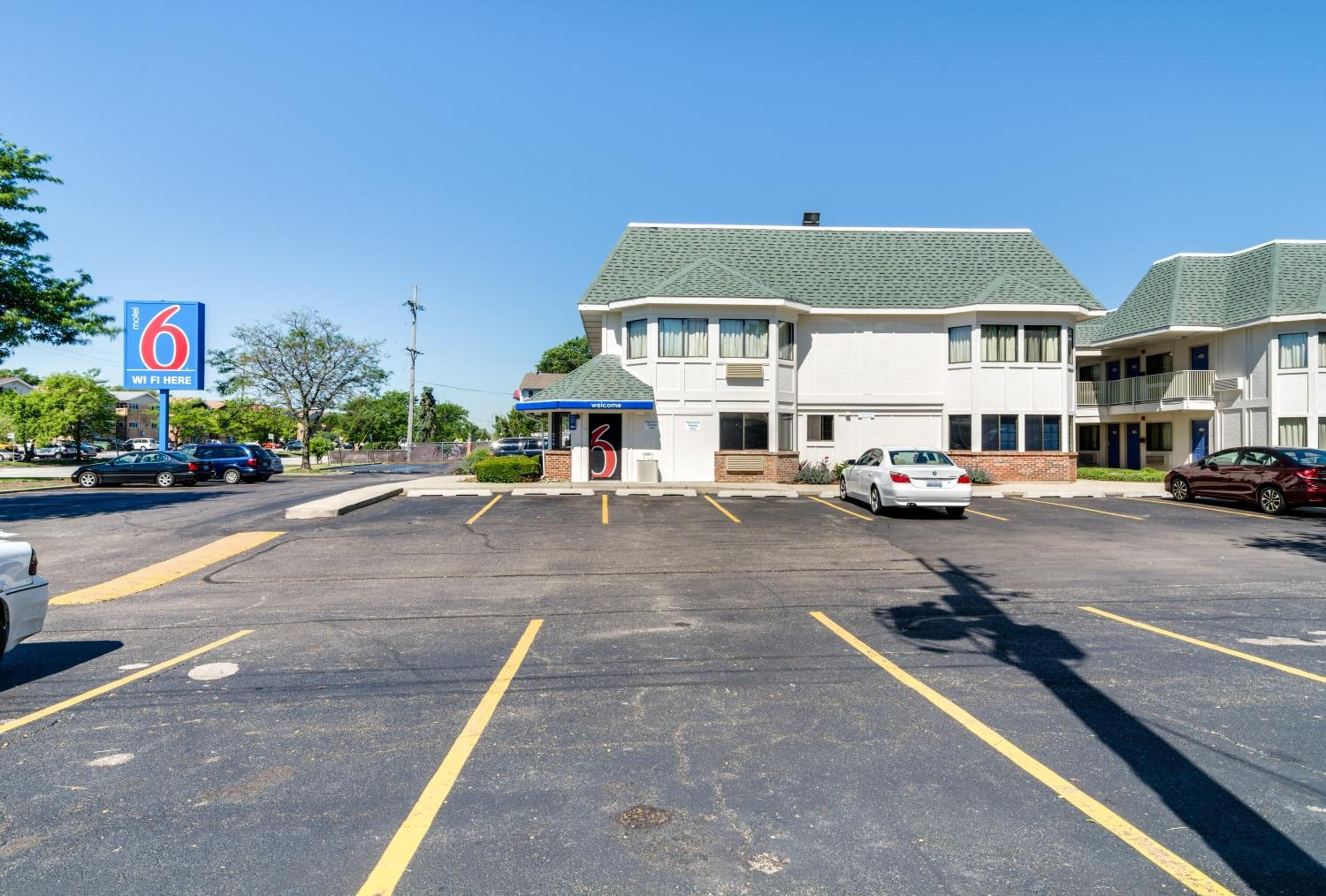 Motel doté de 6 réseaux Wi-Fi, d’un parking et où plusieurs voitures sont stationnées.