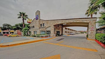 A McDonald's restaurant with a stone facade, an overhang, and a parking lot with marked lanes.