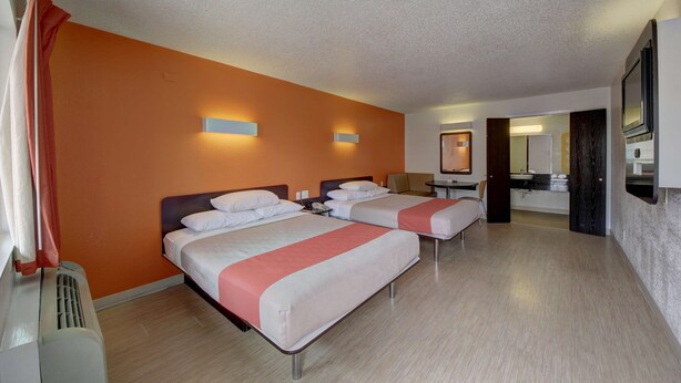 Une chambre d’hôtel avec deux lits, une salle de bain et un téléviseur.