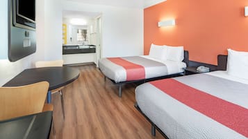 Camera d'albergo con due letti, una scrivania e una televisione.