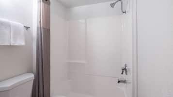 A bathroom with a shower, toilet, and bathtub.