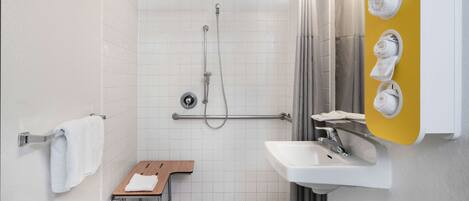 A modern bathroom with a shower, a sink, and a towel rack.