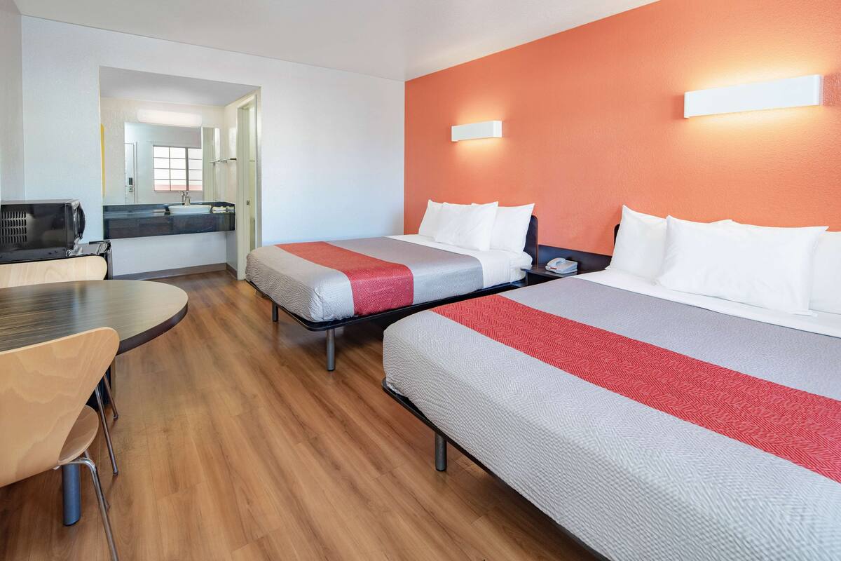 Une chambre d’hôtel avec deux lits, une table à manger et un coin cuisine.