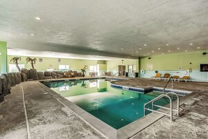 Una piscina techada, sillones reclinables de piscina