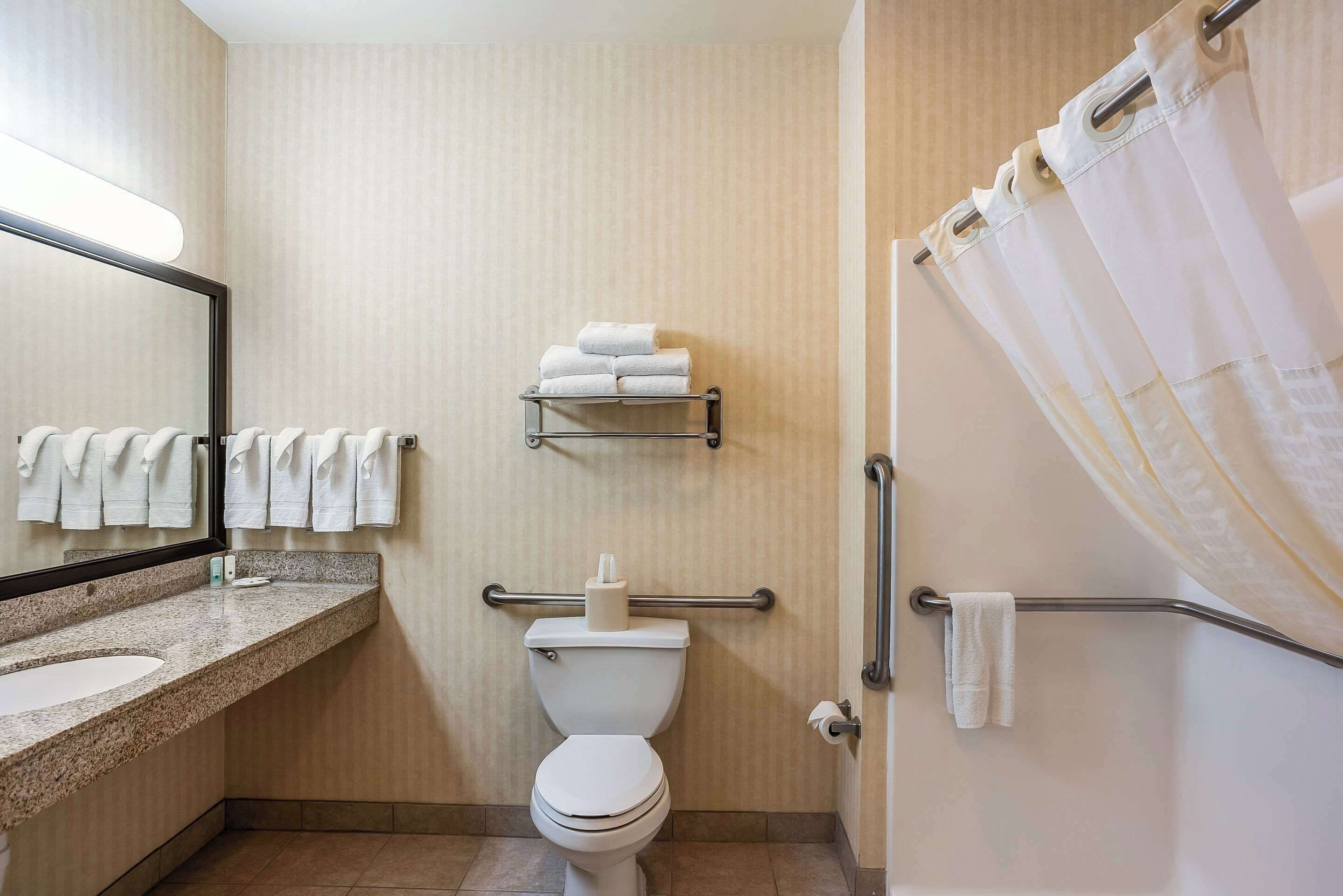 A modern bathroom with a toilet, sink, and shower area.