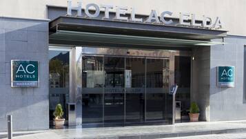 L’extérieur de l’hôtel Elida, qui fait partie de la chaîne AC Hotels Marriott, se distingue par sa façade moderne et son entrée dotée de portes vitrées.