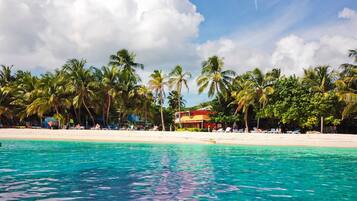 On the beach, white sand, sun loungers, beach towels