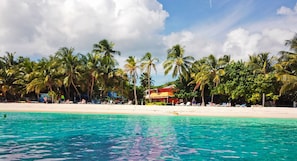 On the beach, white sand, sun-loungers, beach towels