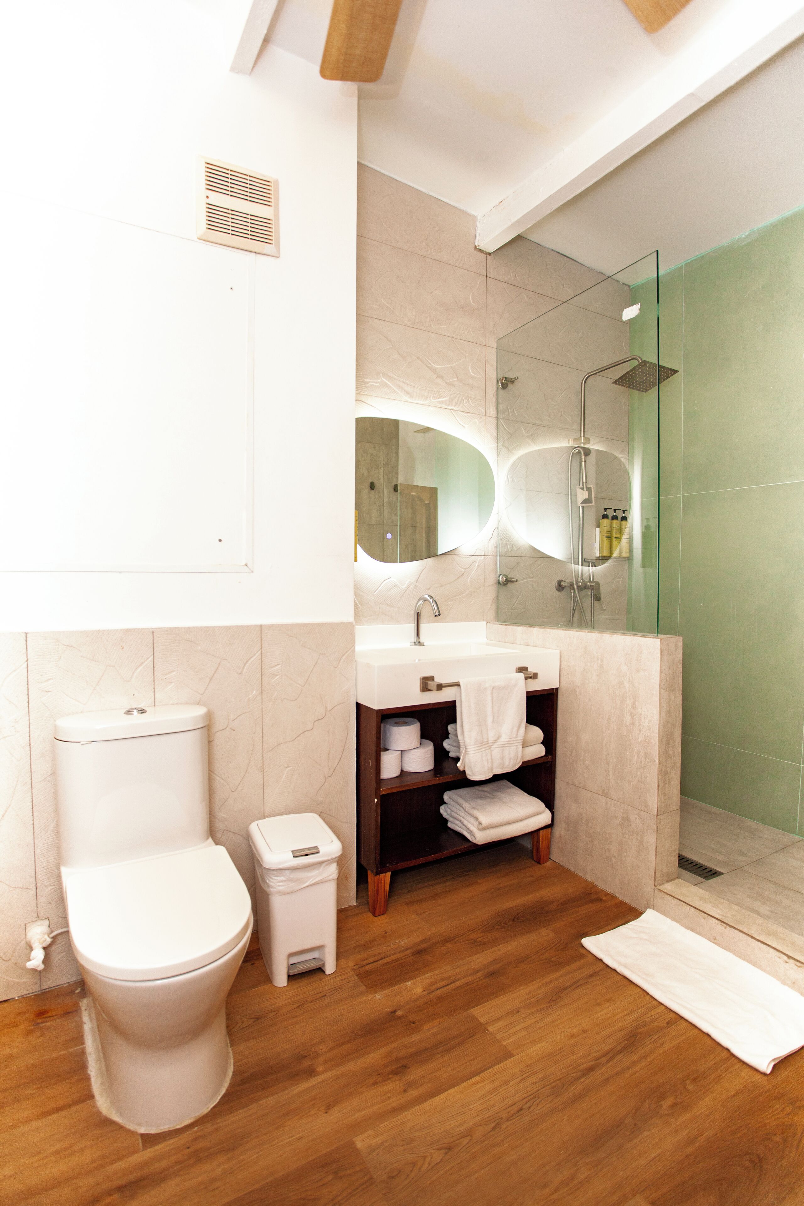 A modern bathroom with a toilet, sink, and shower.