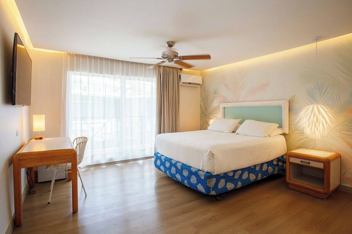 Una habitación de hotel con una cama, un escritorio y una silla.