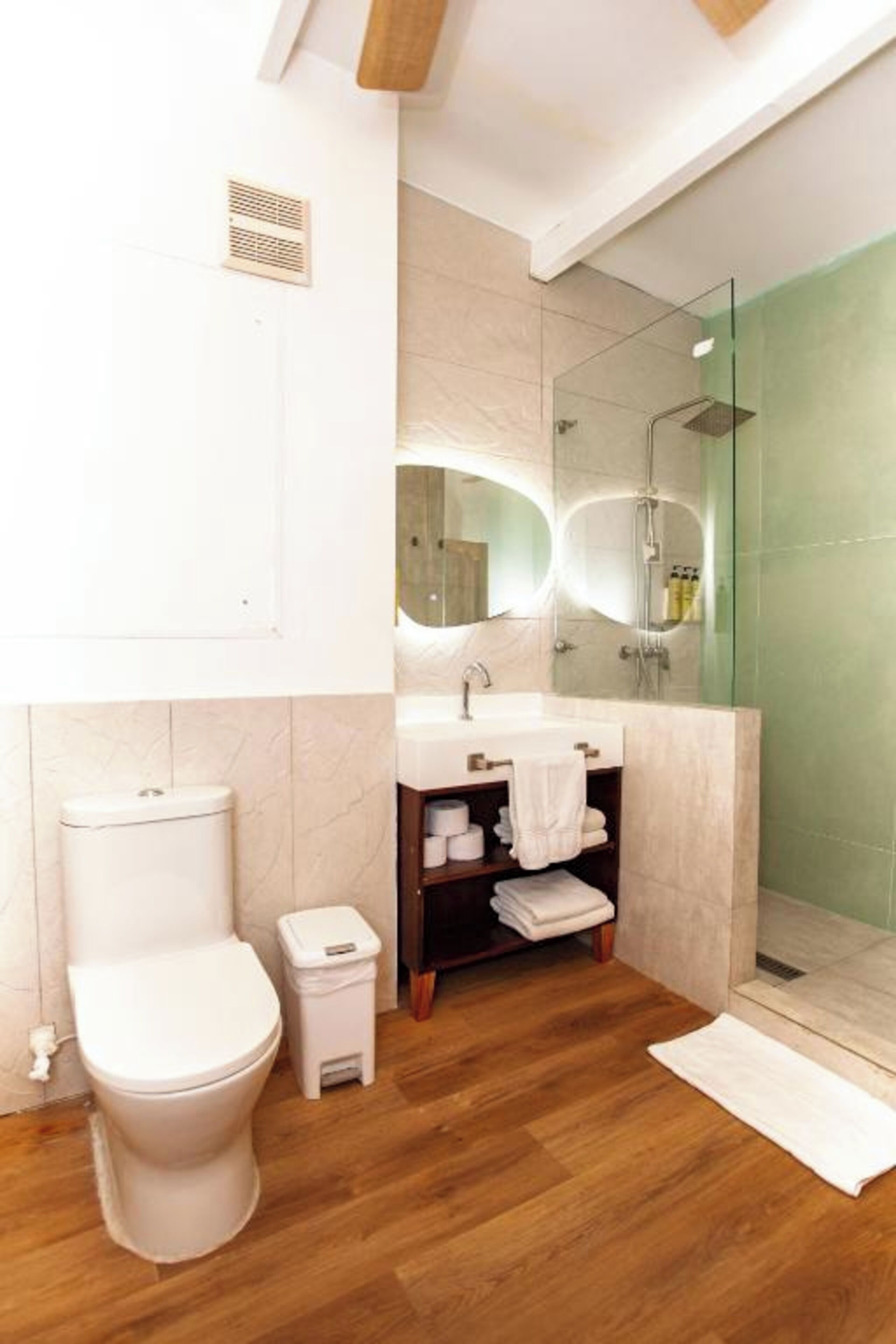 A modern bathroom with a toilet, sink, and shower.