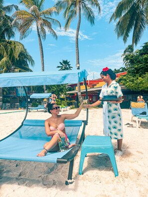 On the beach, white sand, sun loungers, beach towels