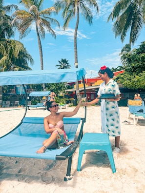 On the beach, white sand, sun loungers, beach towels
