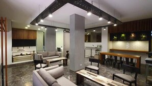 A modern hotel lobby with a reception desk, seating area, and a bar. - Hotel Mendoza (Mendoza)