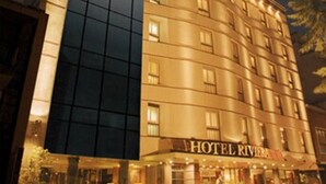 Un hotel con fachada moderna de vidrio y sección de edificio clásico.