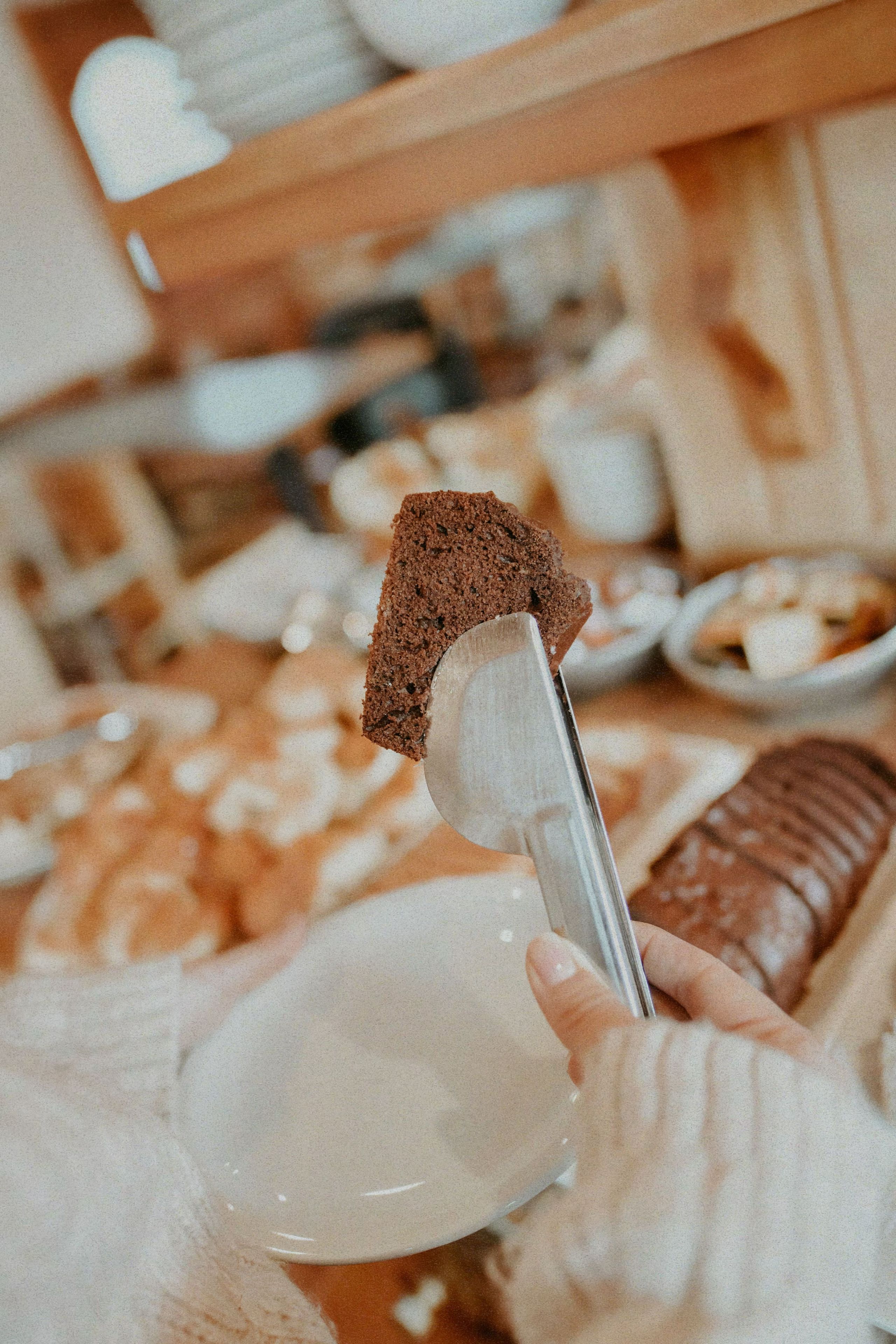 A hand holding a slice of bread with a fork.