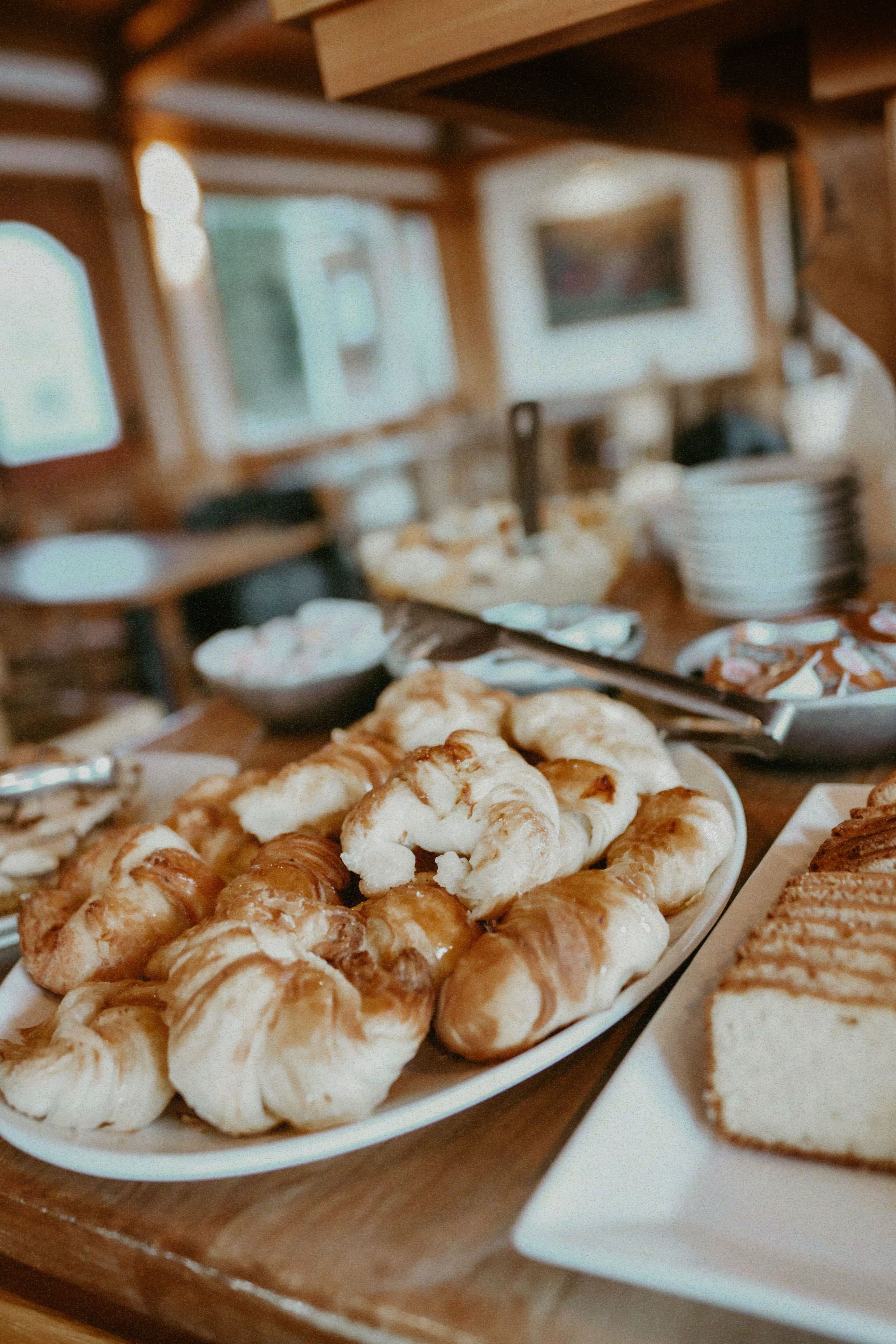 Une table de buffet proposant divers plats, notamment des pâtisseries et une grande part de gâteau.