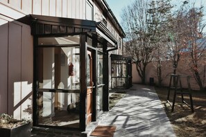 A building with a covered entrance, a fire extinguisher, and a clear pathway leading to the entrance. -  Del Bosque Apart & Hotel (Ushuaia)