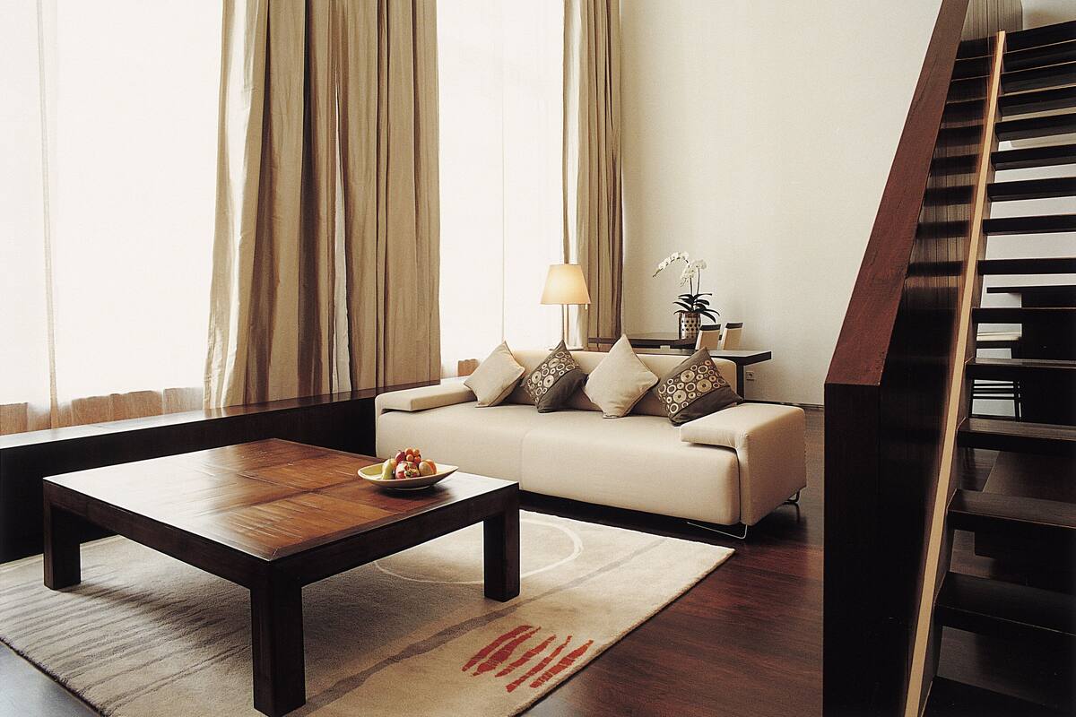 A living room with a sofa, coffee table, and a staircase.