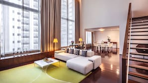 A modern hotel room with a large window, a sofa, a dining area, and a staircase. - COMO Metropolitan Bangkok (Bangkok)