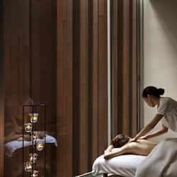Experience a serene massage therapy session in a peaceful, well-lit room with a large window and soothing ambiance.