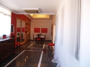 A hotel room with a dining area, a mirror, and artwork on the walls. - Hotel Corona de Atarfe (Atarfe)