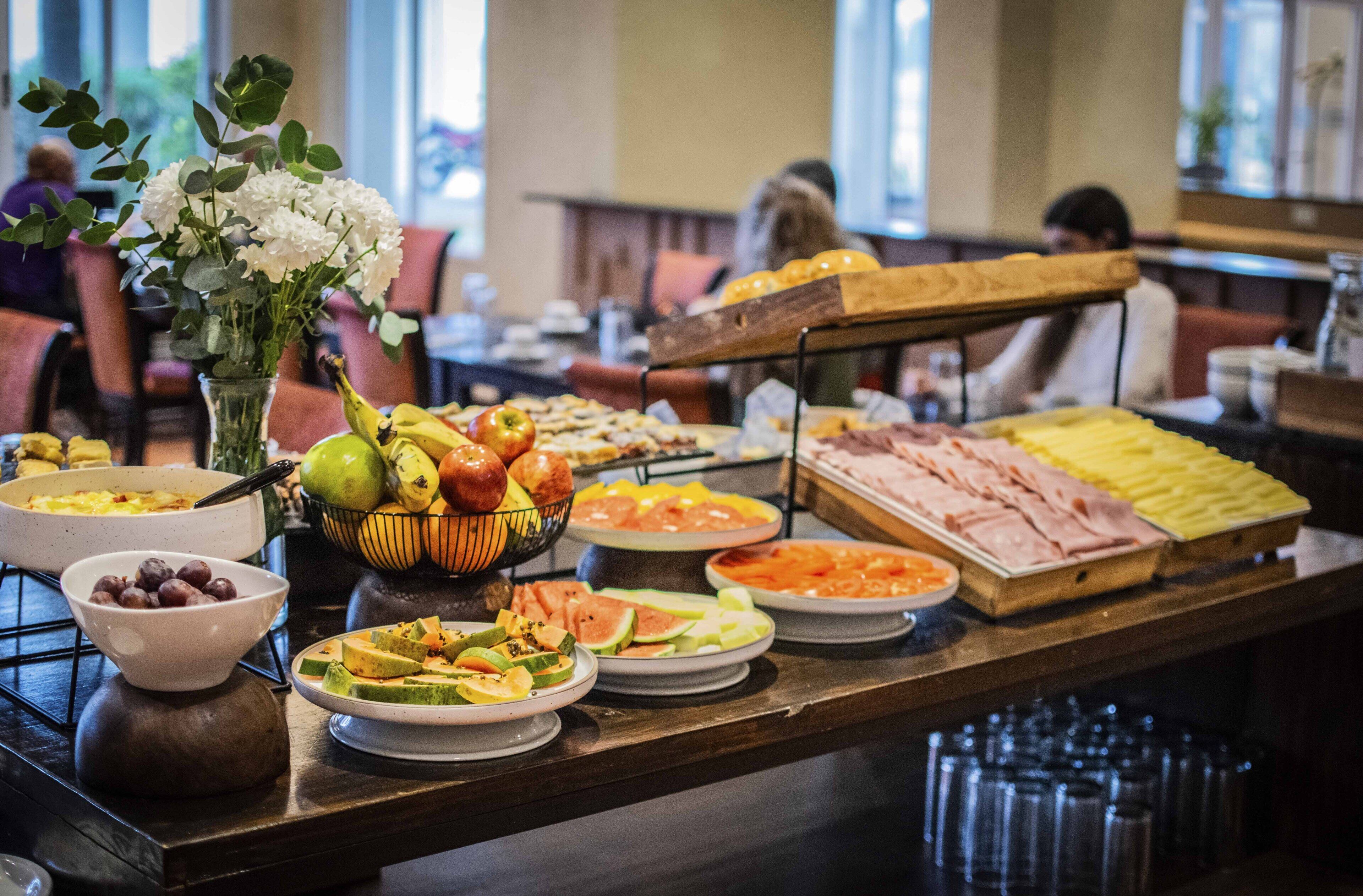 A buffet with various food items including fruits, vegetables, and meats.