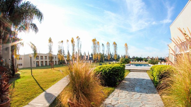 Un patio con un camino de piedra, una piscina y un edificio con techo plano.