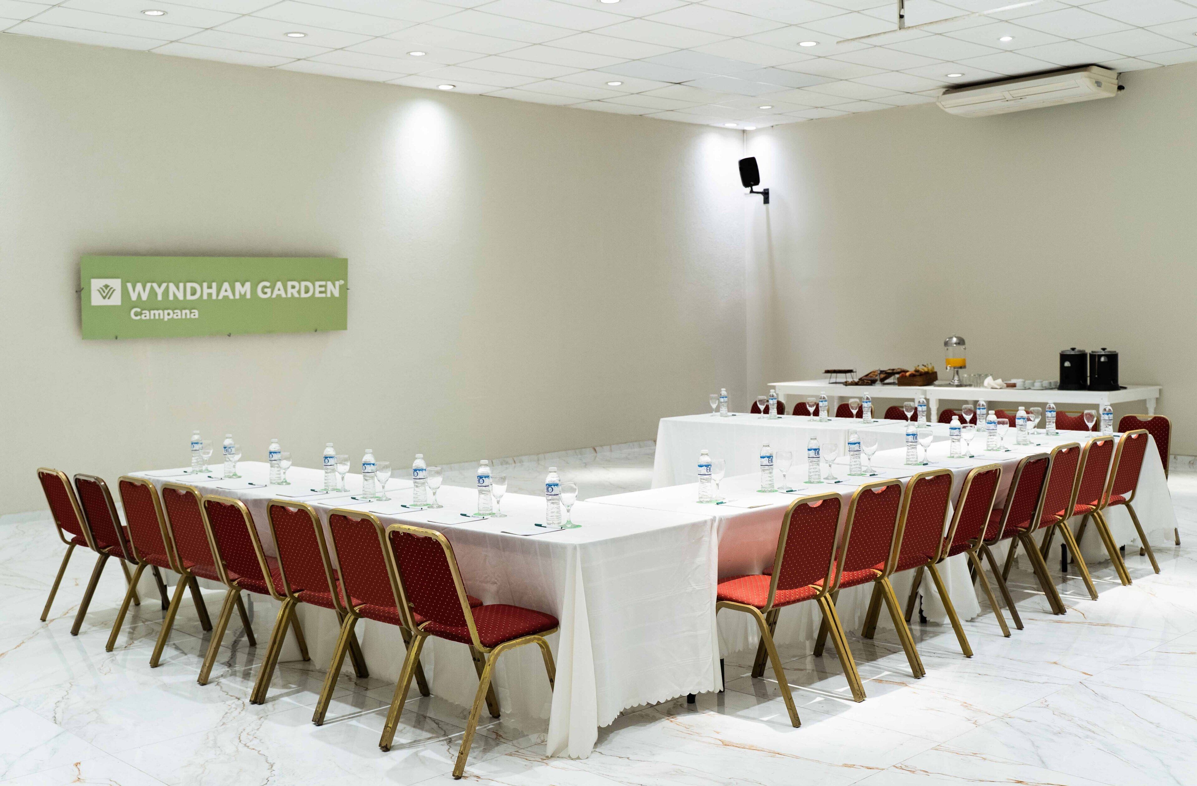 A conference room with tables set for a meeting, equipped with water bottles and glasses.