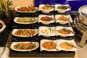 Een buffet met diverse gerechten en bestek.
